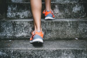 Woman climbing a flight of steps to add daily movement after 40
