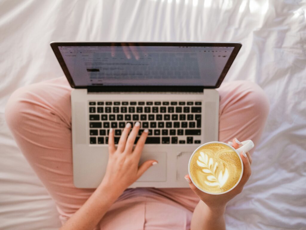 sincerely-media-ylveRpZ8L1s-unsplash Woman working on a laptop while sipping coffee